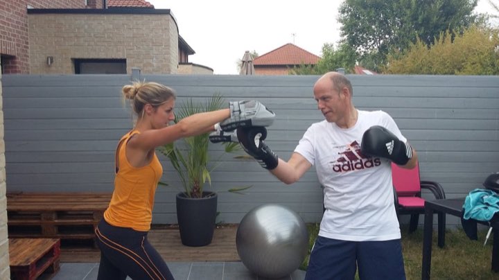 Aurélie Blot tenant les pattes d'ours pour un client en séance de boxe en extérieur